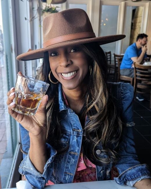 Lynette Charles holding a glass of alcohol