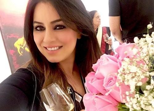 Mahima Chaudhary holding a glass of white wine