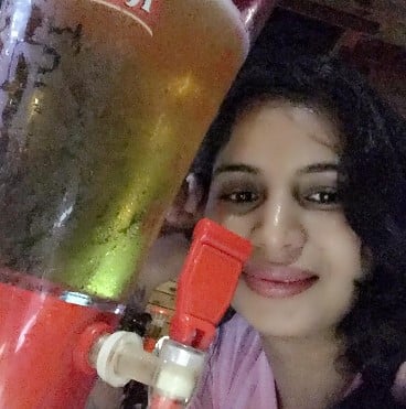 Mallika Rajput posing with a jar of beer