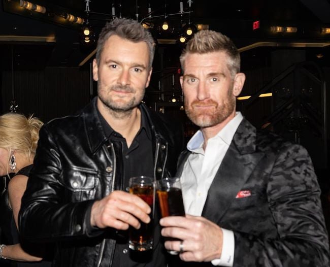 Marty Smith holding a glass of alcohol