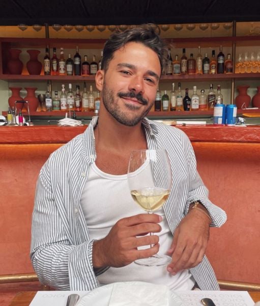 Mateus Pires drinking wine at a restaurant