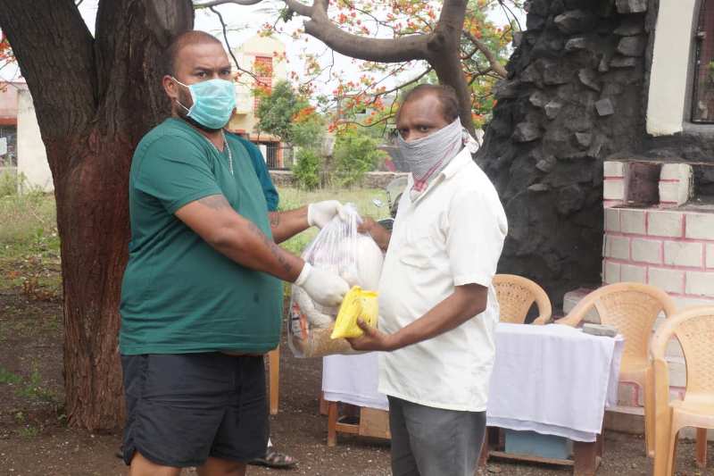 Mauris Noronha (left) distributing ration during COVID-19 lockdown
