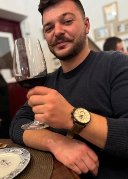 Micael Miquelino drinking red wine at a restaurant in his hometown