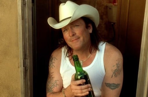 Michael Madsen posing with a bottle of beer