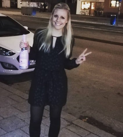 Michaela Benthaus posing with a bottle of alcohol