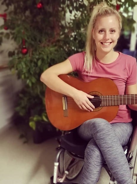 Michaela Benthaus while playing a guitar