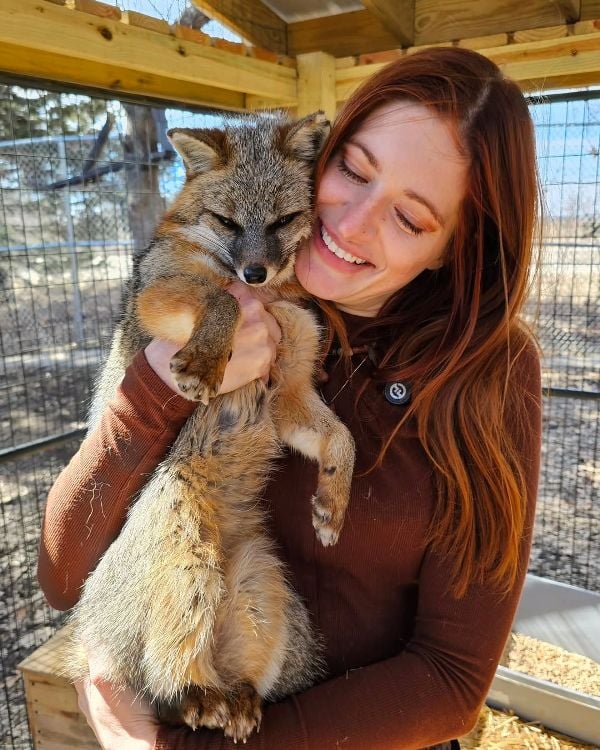 Mikayla Raines posing with a rescued fox