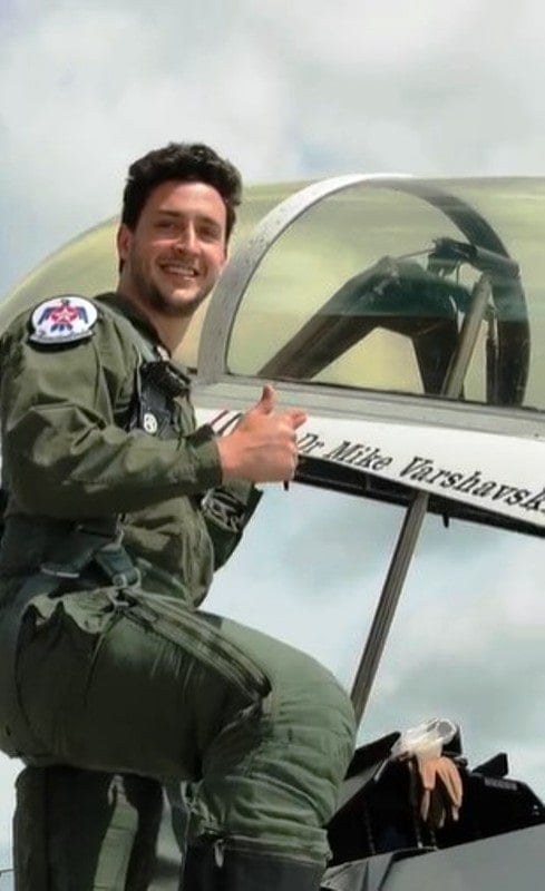 Mike standing next to the cockpit of an F-16 fighter jet