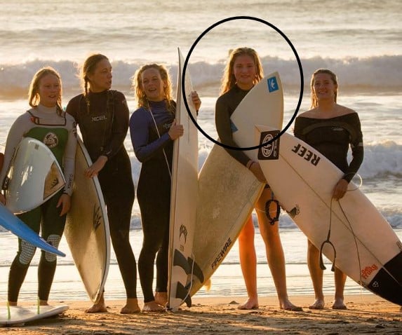 Milla Magee posing with her friends and surfboards