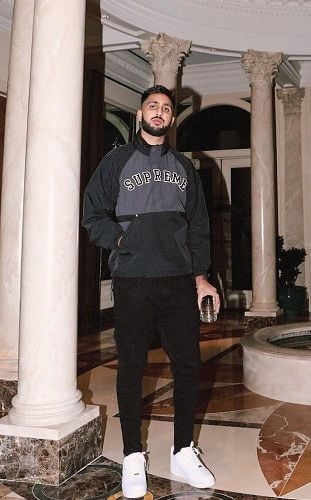 Money Musik holding a glass of alcohol