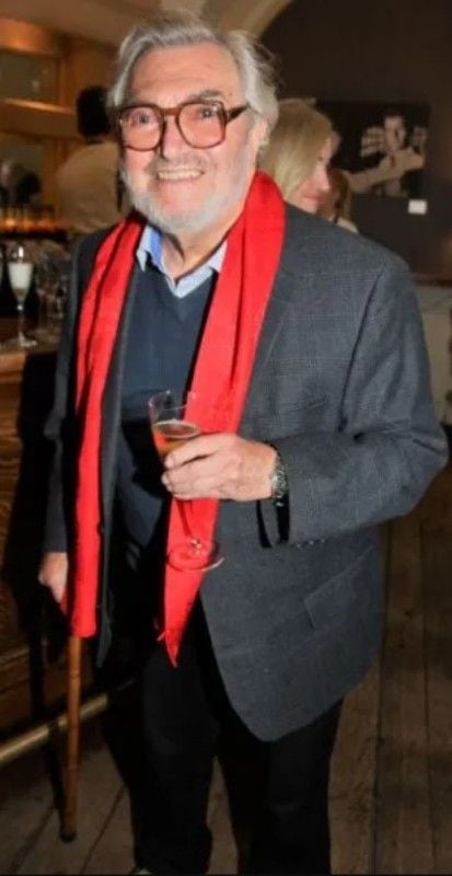 Monty Norman holding a glass of wine