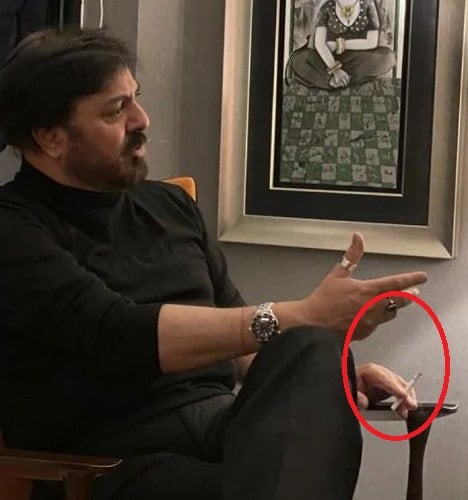 Nauman Ijaz holding a cigarette