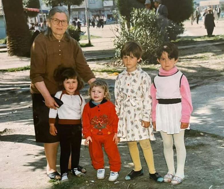 Neda Balluku in childhood with her grandmother and cousins