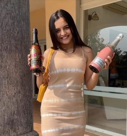 Neha Harsora posing with the bottles of alcohol
