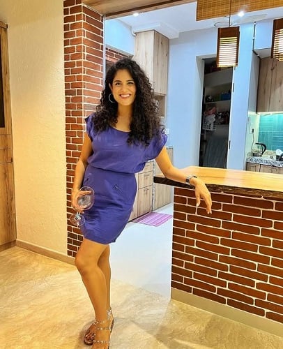 Neha Iyer holding a glass of alcohol