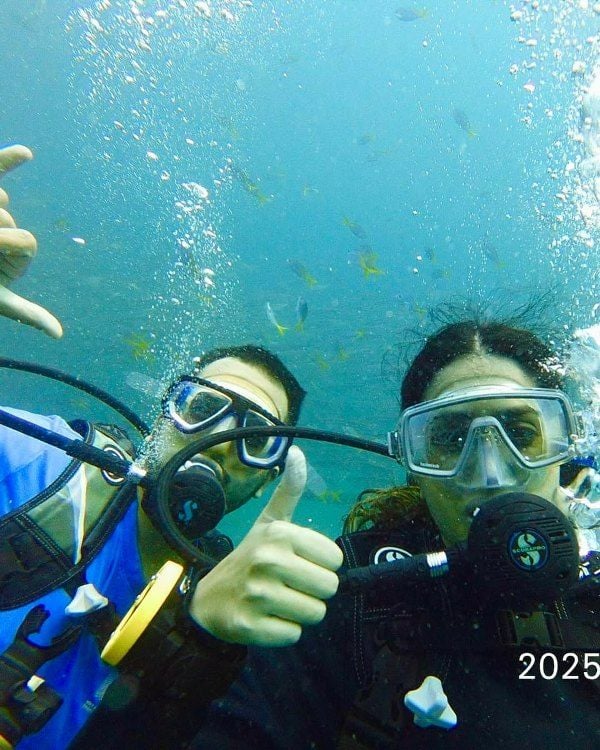 Nikita Luther, scuba diving in Thailand, along with a friend