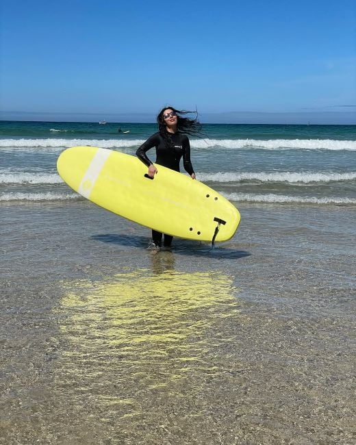 Nisha Aaliya holding the surfboard