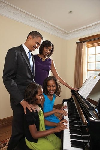 Old picture of Sasha Obama and Malia Obama playing the piano with their parents