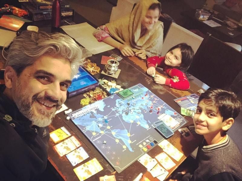 Omair Rana playing boardgame with his family