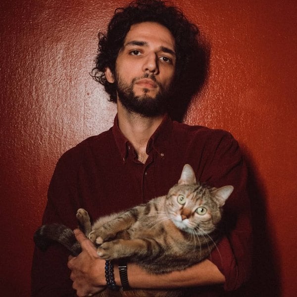 Omar Mebrouk posing with her pet cat