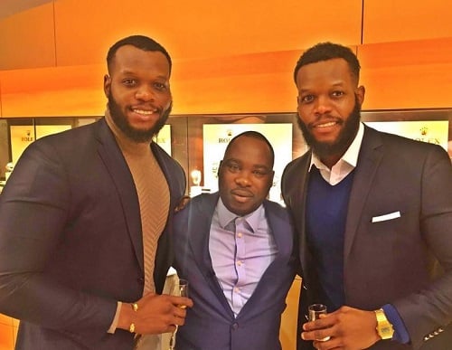 Oseloka Mbadiwe and Ozumba Mbadiwe holding a glass of alcohol