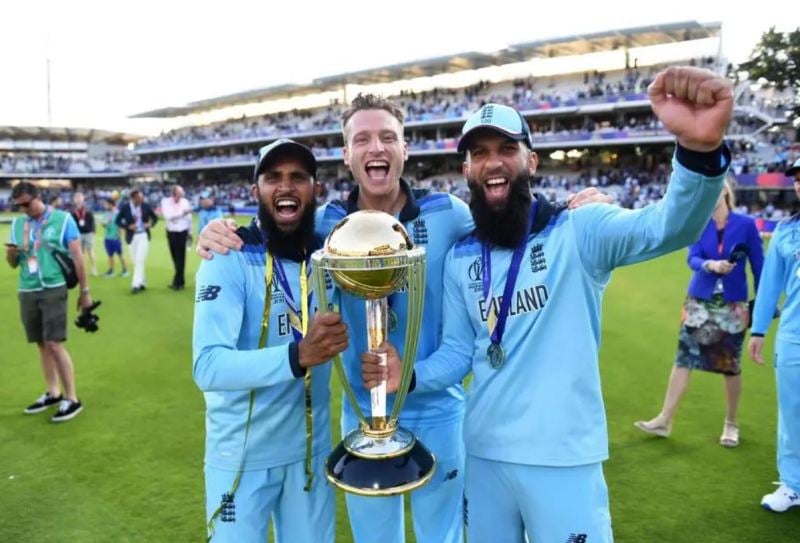 Photo of Adil Rashid, Moeen Ali, and Jos Buttler lifting the 2019 World Cup trophy