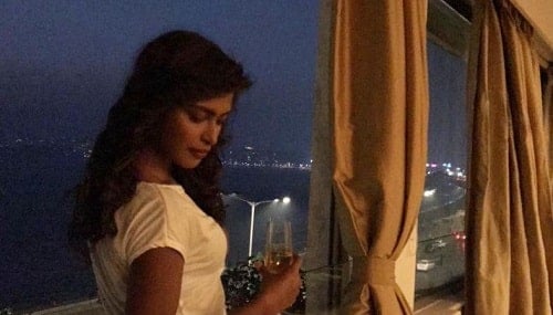 Poulomi Das holding a glass of wine