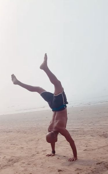 Pradeep Kabra performing a headstand at a beach in Mumbai
