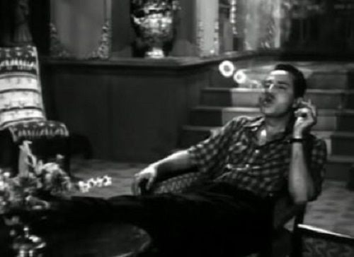 Pran making smoke rings for a scene in a film