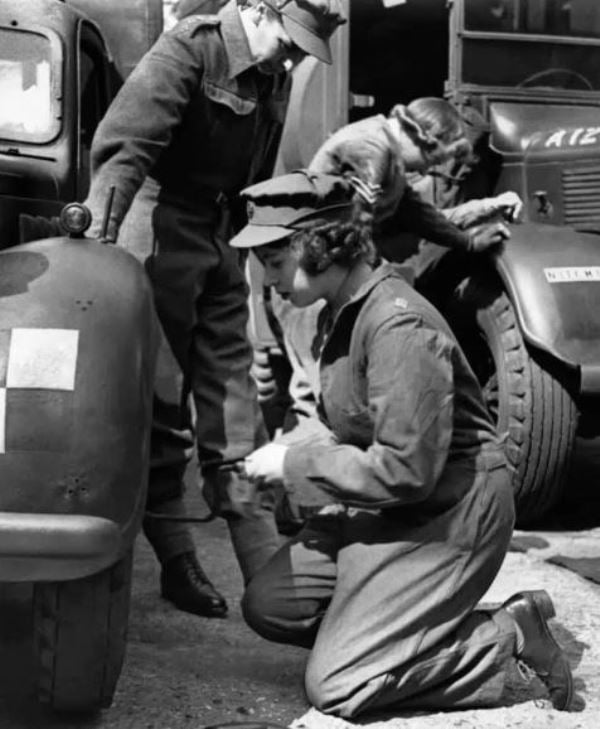 Princess Elizabeth while changing the wheel of her car during training in Southern England in 1945