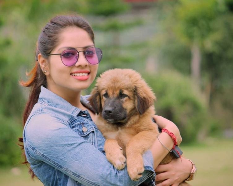 Priya Chauhan posing with a stray dog near her home