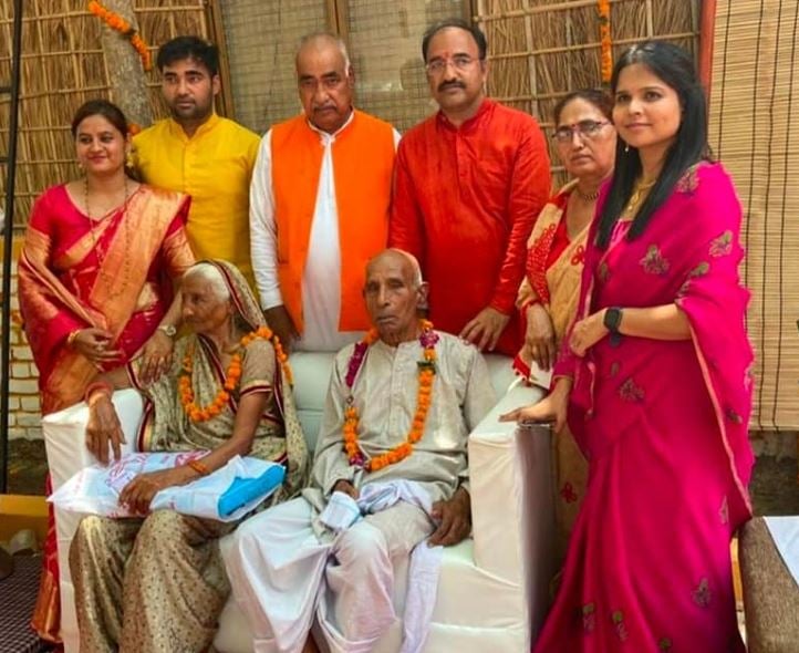 Pulkit Arya (second from left, standing) and his wife, Swati Gola Arya (extreme right)