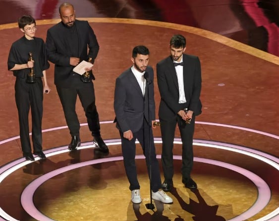 Rachel Szor, Hamdan Ballal, Basel Adra, and Yuval Abraham accept the documentary feature film award for 