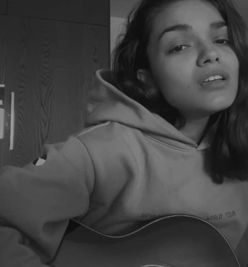 Rachel Zegler playing a guitar