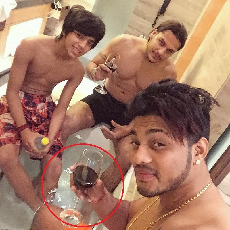 Raftaar holding a glass of wine