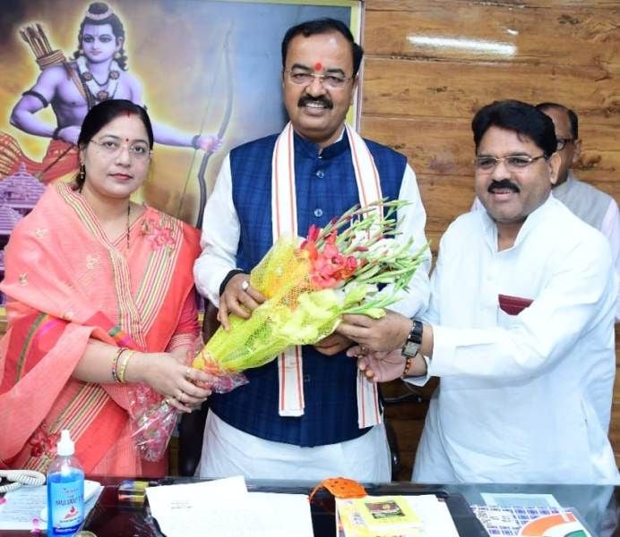 Raghuraj Singh Shakya with his wife presenting a bouquet to Keshav Prasad Maurya