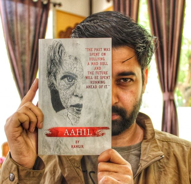 Rahgir posing with his book titled