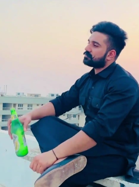 Rana Balachauria posing with a bottle of beer