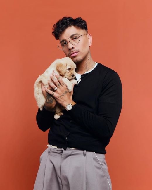 Rauw Alejandro holding a puppy
