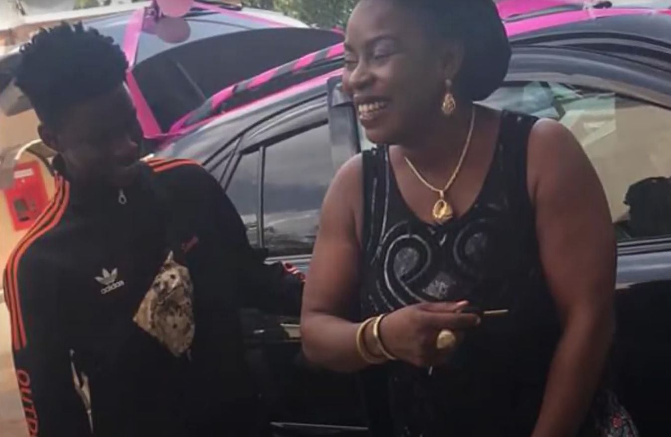 A picture of Rema and his mom with their new car