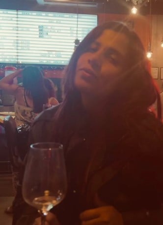 Rhiti Tiwari while posing with a glass of alcohol