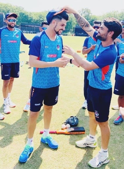 Rinku Singh giving Sameer Rizvi (left) his cap on his debut