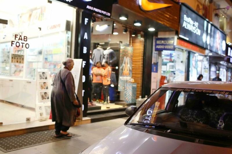 Romila Thapar Walking in front of a Bookseller in the Khan Market Area of Delhi