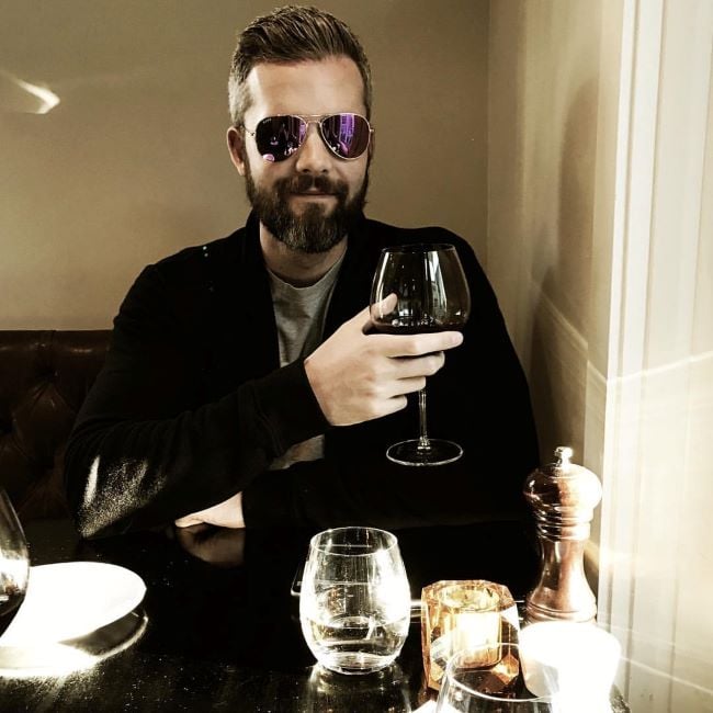 Ryan Serhant holding a glass of wine