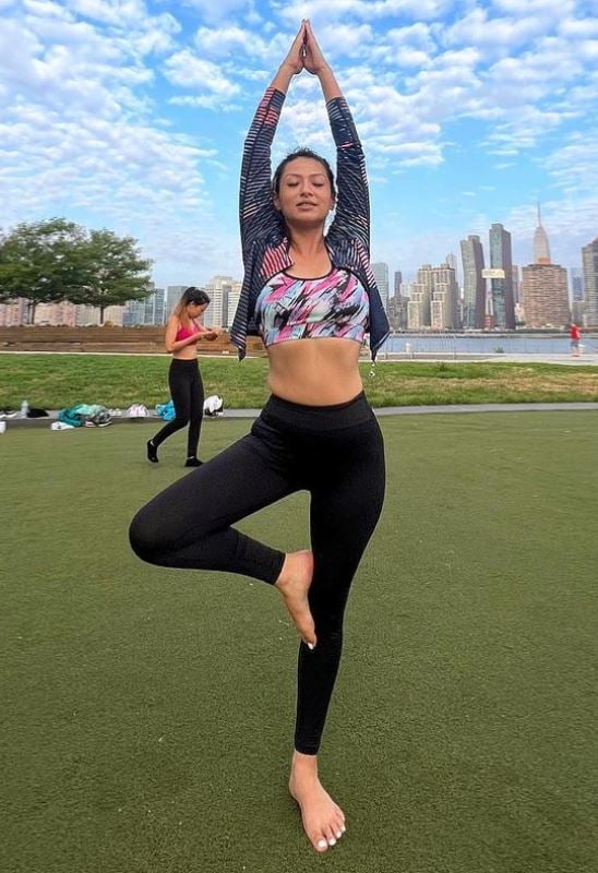 Sahana practising yoga in a park