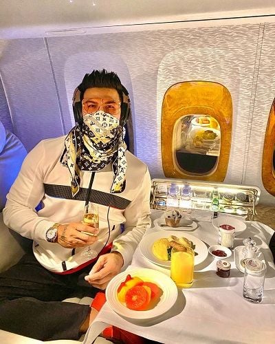 Sahil Khan holding a glass of wine