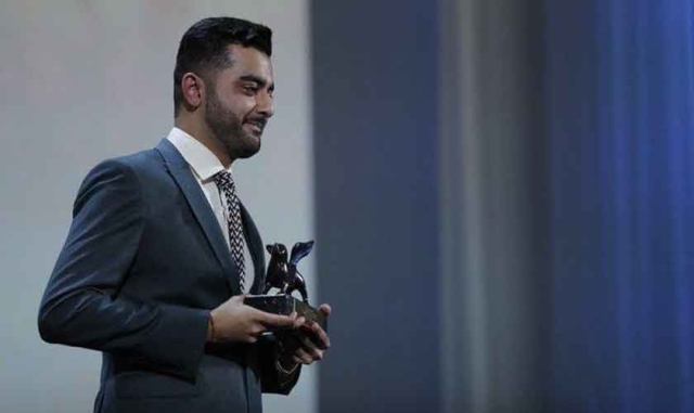 Saim Sadiq holding Orizzonti Award that he received at the 2019 Venice Film Festival