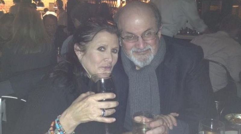 Salman Rushdie while holding a glass of alcohol