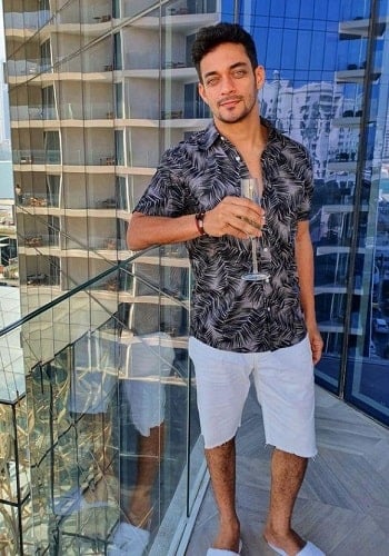 Sam Merchant holding a glass of wine