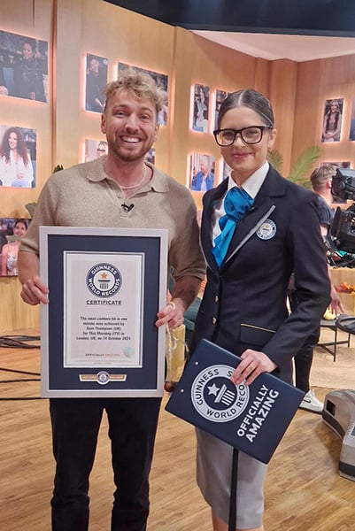 Sam Thompson holding the Guinness World Record certificate for hitting the most conkers